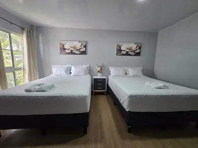 two beds sitting next to each other in a bedroom at Mi Tierra Escalón Hotel y Restaurante in San Salvador