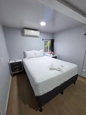 a bedroom with a large white bed in a room at Mi Tierra Escalón Hotel y Restaurante in San Salvador