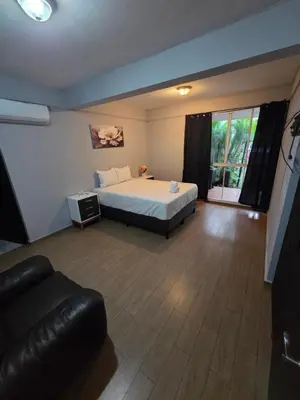 a bedroom with a bed and a couch in it at Mi Tierra Escalón Hotel y Restaurante in San Salvador