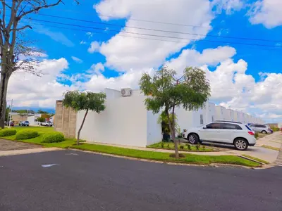 a white building with a car parked in a parking lot at Vista a los Volcanes in Santa Ana