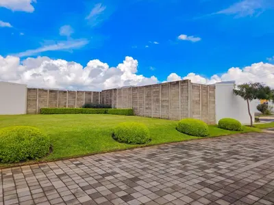 a brick building with a lawn and bushes at Vista a los Volcanes in Santa Ana