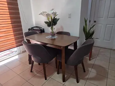 a dining room table with chairs and a vase of flowers at Vista a los Volcanes in Santa Ana