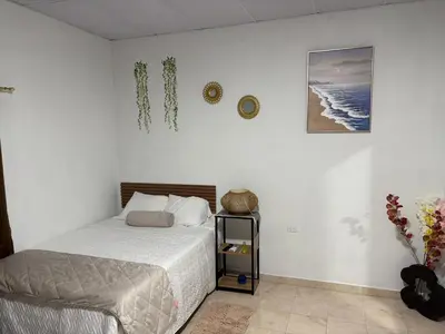 a bedroom with a bed and a clock on the wall at La ceibasurf in La Libertad