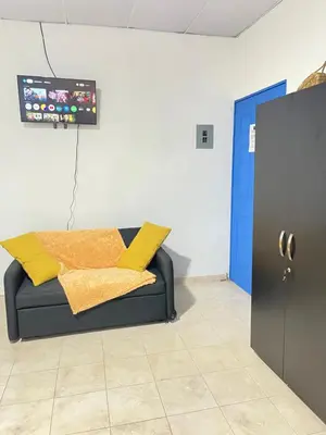 a couch with yellow pillows in a room at La ceibasurf in La Libertad