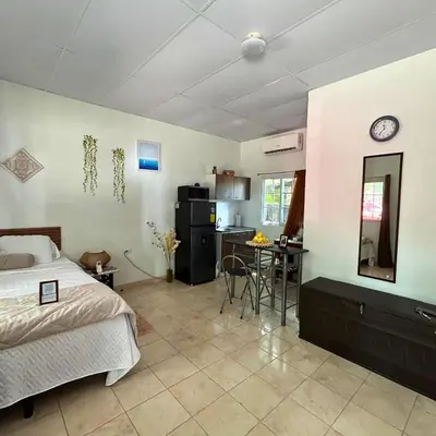 a bedroom with a bed and a table and a kitchen at La ceibasurf in La Libertad