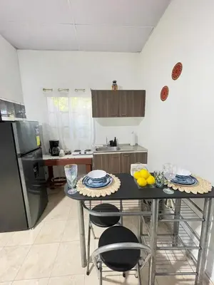 a kitchen with a table with chairs and a refrigerator at La ceibasurf in La Libertad