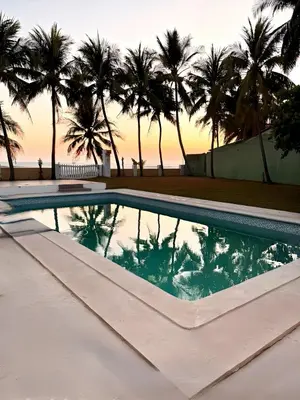a swimming pool with palm trees in the background at Villa Vallarta Costa del Sol in Marcelino