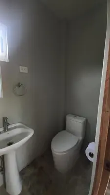 a bathroom with a white toilet and a sink at Villas Oasis Verde in Salcoatitán