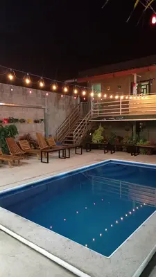 a swimming pool at night with chairs and stairs at Villas Oasis Verde in Salcoatitán