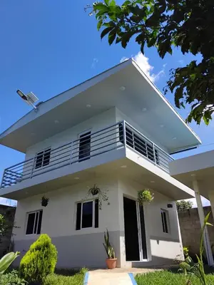 a white house with a balcony at Villas Oasis Verde in Salcoatitán