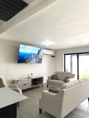 a living room with a couch and a tv on the wall at Luxury Cozy Home in San Miguel