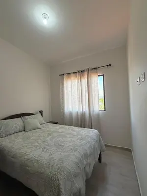 a white bedroom with a bed and a window at Luxury Cozy Home in San Miguel