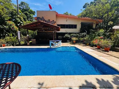 a swimming pool in front of a house at Essenz Bahía in El Níspero