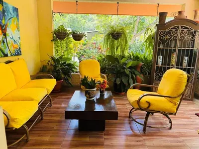 a living room with yellow chairs and a coffee table at Essenz Bahía in El Níspero