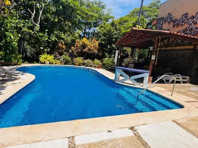 a large blue swimming pool with a pavilion at Essenz Bahía in El Níspero
