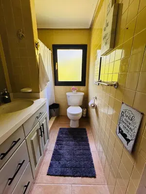 a bathroom with a toilet and a sink and a window at Essenz Bahía in El Níspero