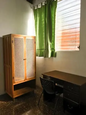 a room with a desk and a green curtain at Hostal Casa del Sol in Suchitoto