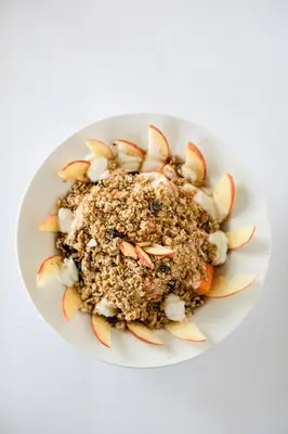 a white plate of food with apples and nuts at Hostal Casa del Sol in Suchitoto