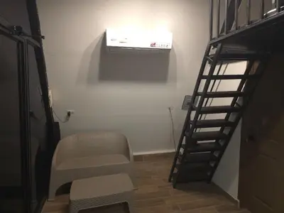 a stairway with a chair and a heater in a room at Cozy A-Frame Beach Cabin Sihu-A Casa in Las Piedras