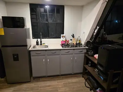 a small kitchen with a sink and a refrigerator at Cozy A-Frame Beach Cabin Sihu-A Casa in Las Piedras