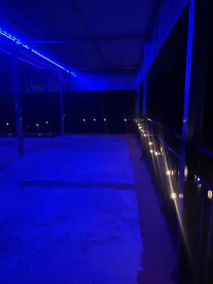 a dark room with blue lights and a fence at Evolution Home in Las Flores