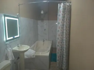 a bathroom with a sink and a tub and a shower at Cabañas La China in El Congo