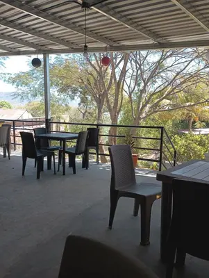 a patio with a table and chairs and a fence at Cabañas La China in El Congo