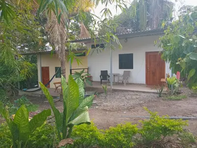 a white house with a table and chairs in front of it at Cabañas La China in El Congo