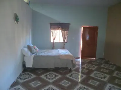 a small bedroom with a bed and a window at Cabañas La China in El Congo