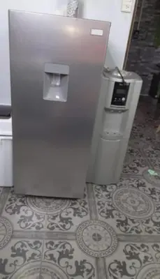 a refrigerator and a trash can on a tile floor at Casa completa, cómoda y céntrica in San Salvador
