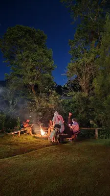 a group of people sitting around a fire at night at Hostal El Pital Lecho de Flores in Nanastepeque