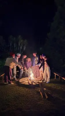 a group of people standing around a fire at Hostal El Pital Lecho de Flores in Nanastepeque