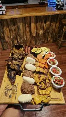 a tray of food with different types of meat and vegetables at Hostal El Pital Lecho de Flores in Nanastepeque