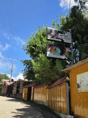 a sign on a fence next to a building at Hostal El Pital Lecho de Flores in Nanastepeque