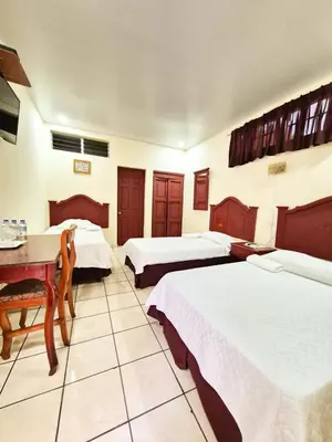 a hotel room with two beds and a table at Hotel Continental Plaza in San Miguel