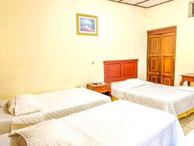 two beds in a room with white walls at Hotel Continental Plaza in San Miguel
