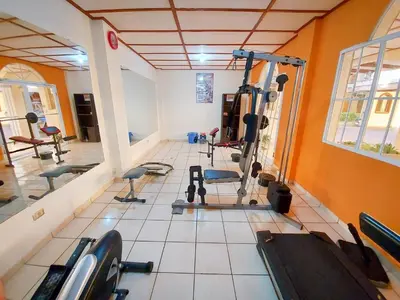 a gym with several tread machines in a room at Hotel Continental Plaza in San Miguel