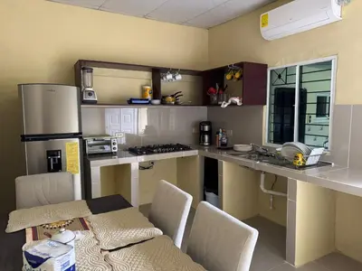 a kitchen with a counter and a table and chairs at Relax House in Sonsonate