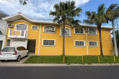 a yellow house with a car parked in front of it at Galería living in San Salvador
