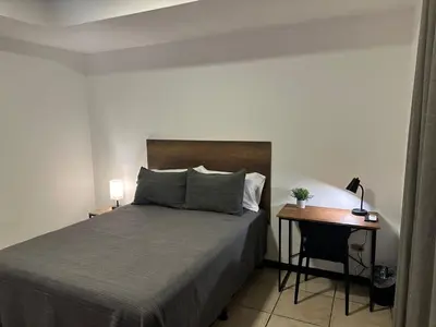 a bedroom with a bed and a desk next to a bed at Agenda Hotel in San Salvador