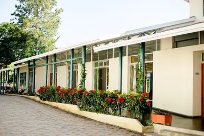 a building with red flowers on the side of it at Hostal Casa del Sol Apartamento in Suchitoto