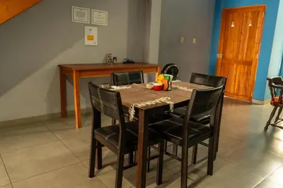 a dining room table with black chairs and a table and a table and chairsktop at Hostal Casa del Sol Apartamento in Suchitoto