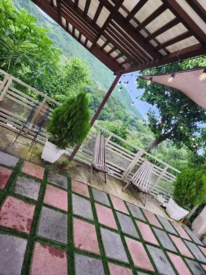 a balcony with chairs and an umbrella and a view at Casa campo Morales in Apopa