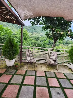 two chairs on a patio with a fence and trees at Casa campo Morales in Apopa