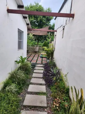 a garden with a stone walkway between two buildings at Casa campo Morales in Apopa