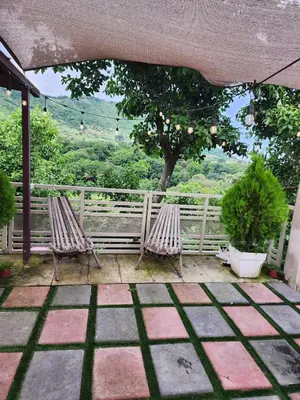 two chairs on a patio with a view of a tree at Casa campo Morales in Apopa