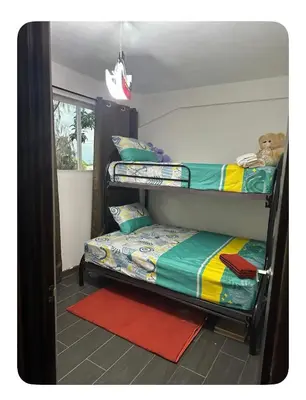 a room with two bunk beds and a door with a rug at Apartamento estadio CUSCATLAN in San Salvador