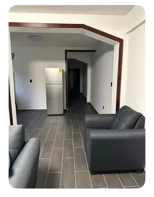 a living room with a couch and a refrigerator at Apartamento estadio CUSCATLAN in San Salvador