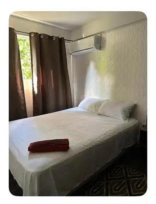 a bed with a red towel on top of it at Apartamento estadio CUSCATLAN in San Salvador