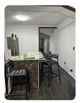 a kitchen with a table and chairs in a room at Apartamento estadio CUSCATLAN in San Salvador